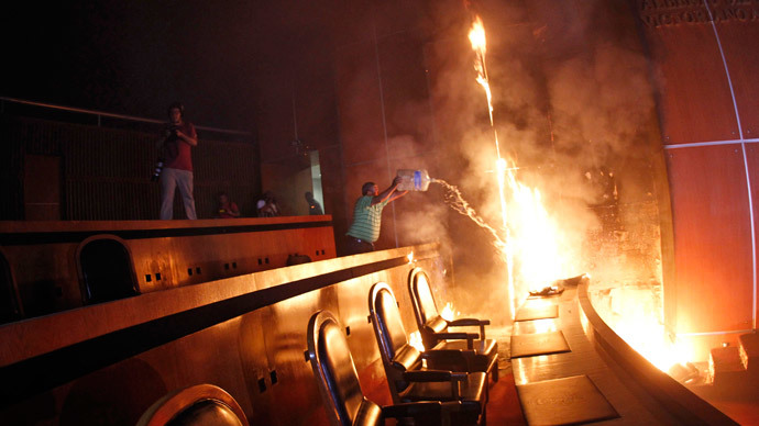 A man tries to extinguish a fire set alight at the principal hall of the City Congress by members of CETEG (State Coordinator of Teachers of Guerrero teacher's union), in Chilpancingo, November 12, 2014. (Reuters / Jorge Dan Lopez)