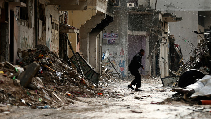 A Palestinian man runs for cover from rain near houses that witnesses said were destroyed or damaged by Israeli shelling during the most recent conflict between Israel and Hamas, in the east of Gaza City.(Reuters / Mohammed Salem)