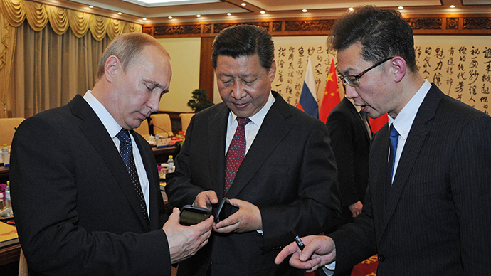 Russian President Vladimir Putin (L) presents a Russian-produced smartphone YotaPhone-2 to Chinese President Xi Jinping at their meeting, November 9, 2014. (RIA Novosti / Michael Klimentyev) 