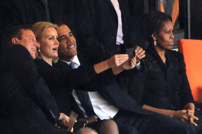 US President Barack Obama (R) and British Prime Minister David Cameron pose for a selfie picture with Denmark's Prime Minister Helle Thorning Schmidt (C) next to US First Lady Michelle Obama (R) during the memorial service of South African former president Nelson Mandela at the FNB Stadium (Soccer City) in Johannesburg on December 10, 2013. (AFP Photo)