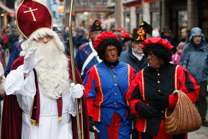 ARCHIVE PHOTO: Saint Nicholas (L) is followed by his two assistants called "Zwarte Piet" (Black Pete) during a traditional parade in central Brussels December 1, 2012 (Reuters / Francois Lenoir)