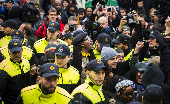 Police control anti-Black Peter demonstrators in Gouda, on November 15, 2014, as the historic city welcomes Sinterklaas, the Dutch version of Santa Claus (Saint Nicolas) and "Zwarte Piet" or Black Peter. Police detaining about 60 protesters (AFP Photo / HO)