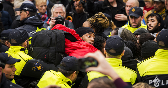 Police control anti-Black Peter demonstrators in Gouda, on November 15, 2014, as the historic city welcomes Sinterklaas, the Dutch version of Santa Claus (Saint Nicolas) and "Zwarte Piet" or Black Peter. Police detaining about 60 protesters (AFP Photo / HO)