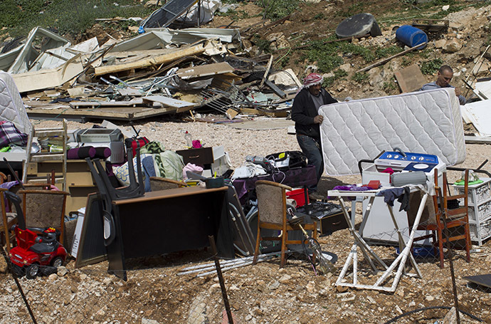 Palestinians collect their belongings after their house was demolished by Israeli bulldozers in the Arab east Jerusalem neighbourhood of Beit Hanina on March 19, 2014. (AFP Photo / Ahmad Gharabli)