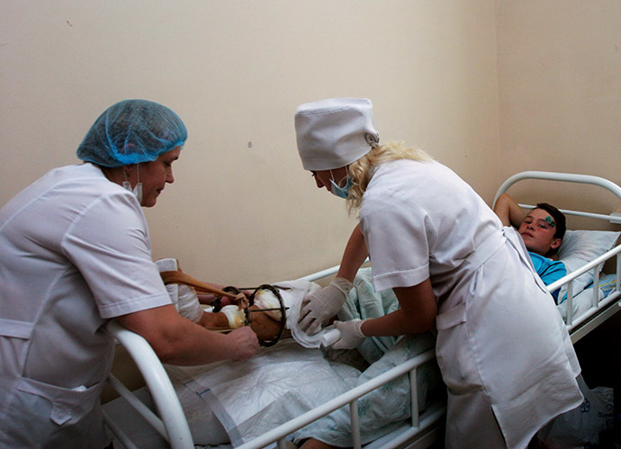 Doctors do a dressing for Vitaly Skrykanyuk who was wounded during the shelling of his school by Ukrainian forces. (RIA Novosti/Igor Maslov)