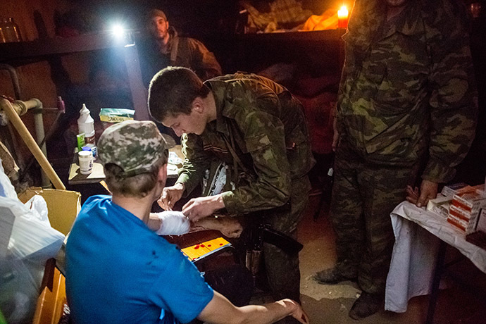 A member of the people's self-defense gives first aid to a person who wounded during a tank attack of the Ukrainian army on Semyonovka village. (RIA Novosti/Andrey Stenin)