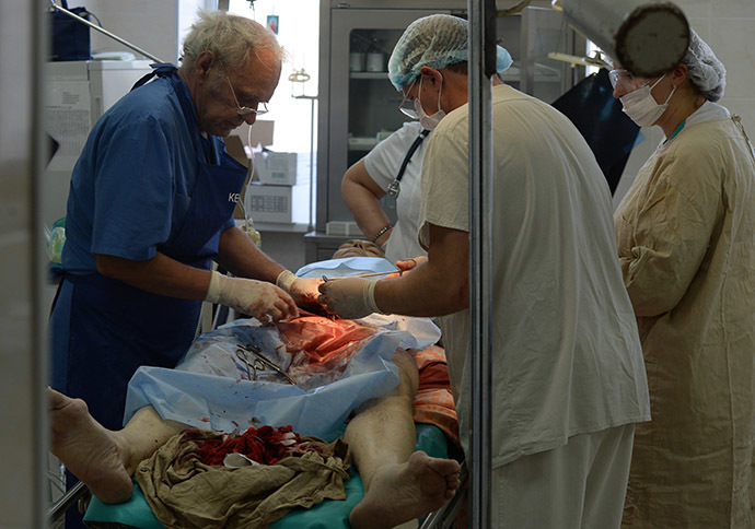Doctors at a city hospital conducting a surgery on a man injured during an artillery attack. (RIA Novosti/Mikhail Voskresenskiy)