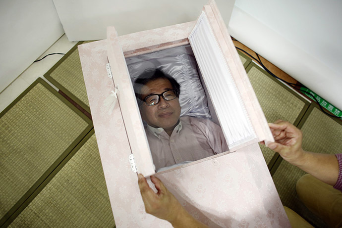 Yoshiya Yoshimura lies in a coffin to try it out during an end-of-life seminar held by Japan's largest retailer Aeon Co in Tokyo October 24, 2014. (Reuters/Toru Hanai)