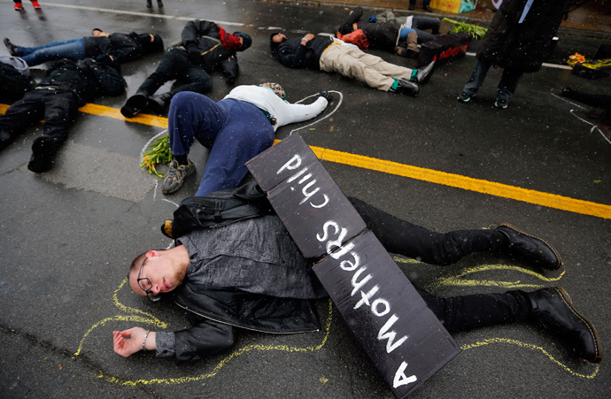 Demonstrators lay on the ground with chalk outlines to represent a mock crime scene during a protest marking the 100th day since the shooting death of Michael Brown in St. Louis, Missouri November 16, 2014 (Reuters / Jim Young)