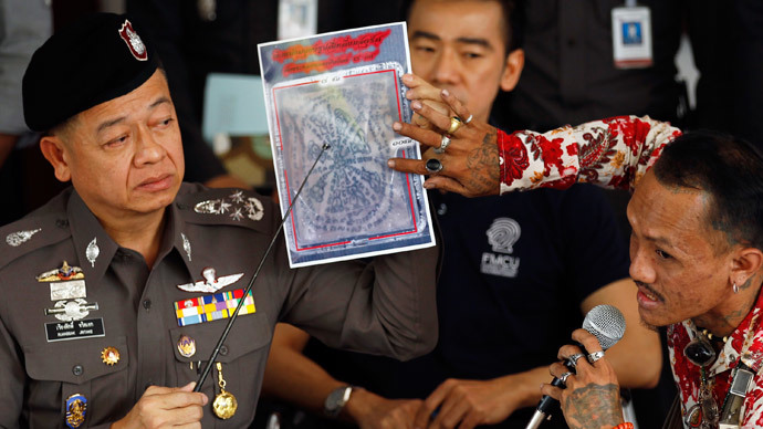 A tattoo expert and a policeman (L) point at one of the pictures of body parts found in parcels as they address reporters in Bangkok November 17, 2014. (Reuters / Chaiwat Subprasom)