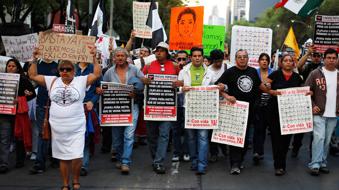 People hold posters and placards during a march for the 43 missing trainee teachers in Mexico City November 16, 2014. Criticism of the government has intensified in Mexico since Attorney General Jesus Murillo said last week that evidence suggests 43 missing trainee teachers were murdered by gunmen and drug gangs in collaboration with corrupt police and local politicians.(Reuters / Bernardo Montoya)