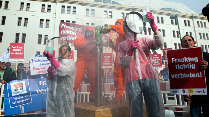 Environmental activists simulate hydraulic fracturing during a protest against fracking in front of the German Ministry of Environment in Berlin on September 30, 2014.(AFP Photo / Bernd Von Jutrczenka)