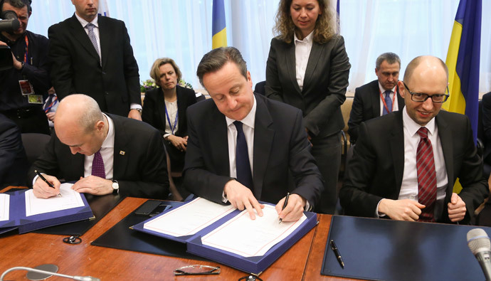 Ukrainian Prime Minister Arseniy Yatsenyuk (R) smiles next to British Prime Minister David Cameron (C) and Swedish Prime Minister Fredrik Reinfeldt (L) as they sign the political provisions of the Association Agreement with Ukraine. (AFP Photo / Pool / Olivier Hoslet)