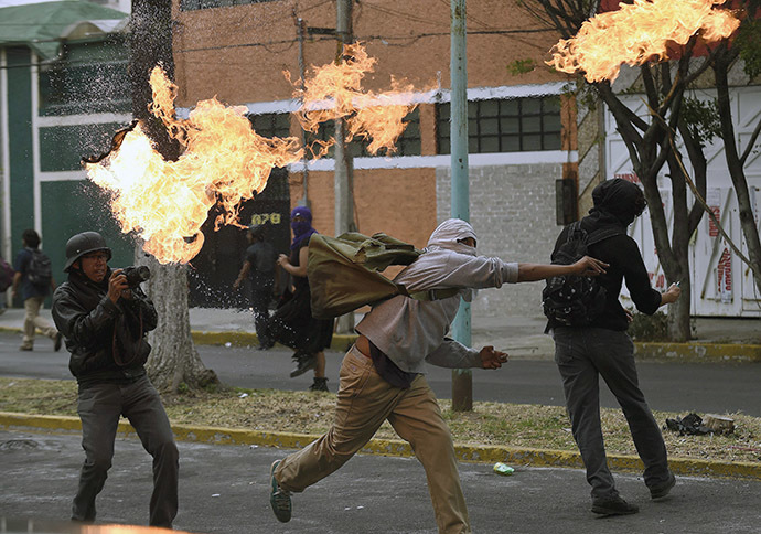 Students furious at the presumed massacre of 43 students clash with the riot police in the surroundings of Mexico City's international airport on November 20, 2014. (AFP Photo/Alfredo Estrella)