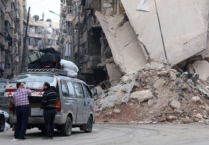A minibus loaded with bags is prepared for a ride near a destroyed building in a rebel-controlled area in the northern Syrian city of Aleppo on November 20, 2014.(AFP Photo/Zein Al-Rifan)