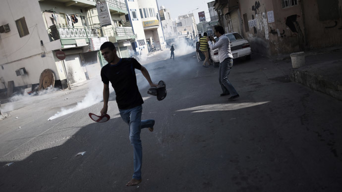 Bahraini protestors run for cover from tear gas fired by riot police during clashes following a rally calling for the boycott of the upcoming parliamentary elections in the Shiite village of Diraz, west of Manama on November 21, 2014.(AFP Photo / Mohammed AL-Shaikh)