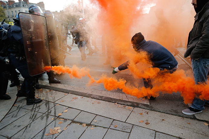 Protestors taunt French riot police with smoke safety flares as the attend a protest demonstration against "police brutality" in Nantes, western France, November 22, 2014 (Reuters / Stephane Mahe)