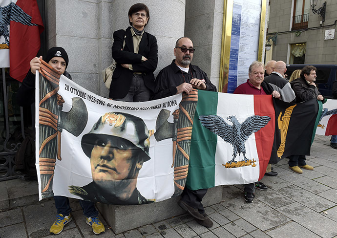 Italian supporters of late Spanish dictator General Francisco Franco and Italian dictator Benito Mussolini stand with flags as they attend the 39th anniversary of the dictator's death, at Plaza de Oriente in Madrid, on November 23, 2014. (AFP Photo/Gerard Julien)