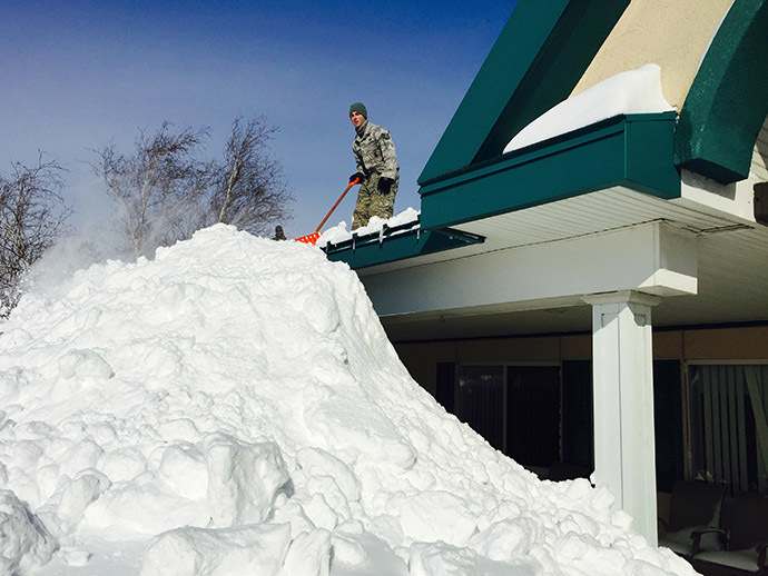 This US National Guard handout photo taken November 19, 2014 shows a New York Air National Guard Airman from the 107th Airlift Wing based in Niagara Falls, New York assisting in snow removal efforts from the roof of the Eden Heights Assisted Living Facility in West Seneca, New York. (AFP Photo /Handout / US National Guard / Maj. Mark Frank)