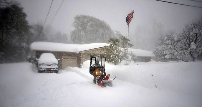 BUFFALO, NY - NOVEMBER 20: Norbert Schnorr attempts to remove some of the five feet of snow from a driveway on November 20, 2014 in the suburb of Lakeview, Buffalo, New York. (AFP Photo/John Normile)