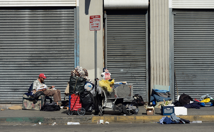Homeless people rest on a public sidewalk in downtown skid row area of Los Angeles, California. (AFP Photo / Kevork Djansezian)