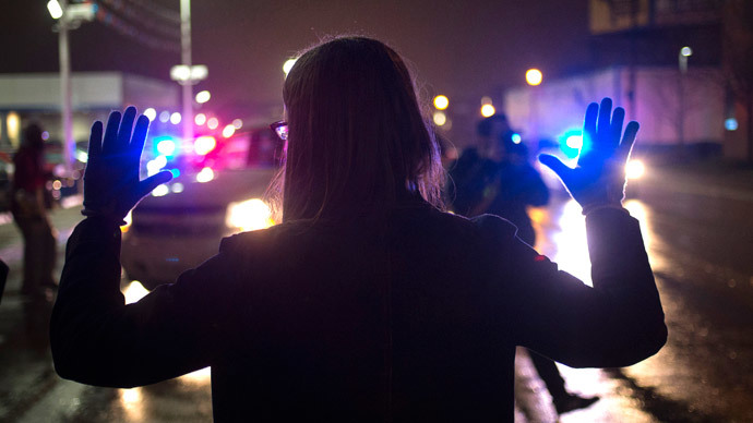 A protester, demanding the criminal indictment of a white police officer who shot dead an unarmed black teenager in August, raises her hands while stopping traffic during a march through a suburb in St. Louis, Missouri November 23, 2014.(AFP Photo / Adrees Latif)