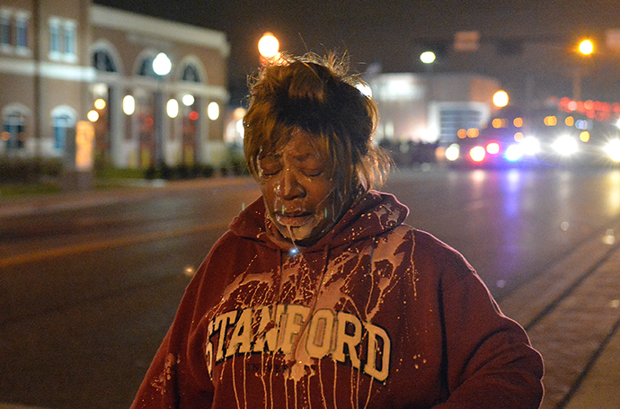A protestor retreats after being treated for tear gas as demonstrators protest the death of 18-year-old unarmed black teenager Michael Brown, who was shot to death by a white police officer, in Ferguson on November 24, 2014 (AFP Photo)