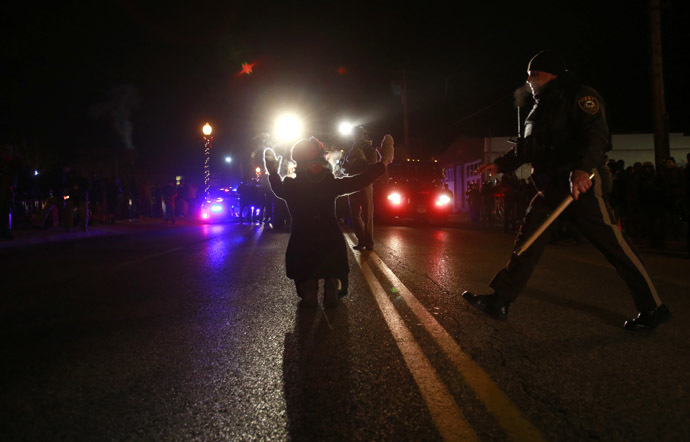 A police officer (R) moves in to arrest a protester on her knees in front of police cars in Ferguson, Missouri, November 25, 2014. (Reuters/Adrees Latif)