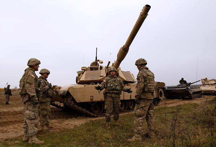 Members of the U.S. 1st Brigade Combat Team, 1st Cavalry Division discuss in front of an Abrams tank during a joint military exercise with Poland's 1st Mechanized Battalion of the 7th Coastal Defence Brigade near Drawsko-Pomorskie November 13, 2014 (Reuters / Kacper Pempel)