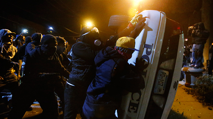 Protesters try to flip over a Ferguson police car, in Ferguson, Missouri, November 25, 2014 (Reuters / Jim Young)