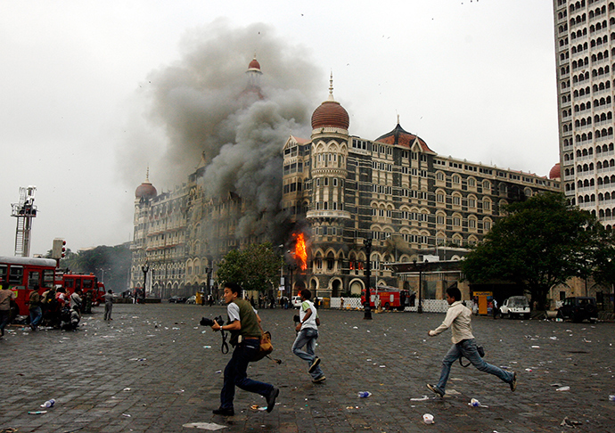 ARCHIVE PHOTO: Photographers run past burning Taj Mahal Hotel during a gun battle in Mumbai November 29, 2008 (Reuters / Arko Datta)