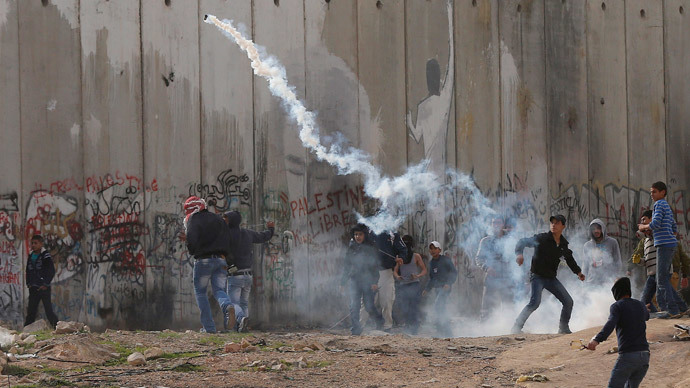 A Palestinian protester returns a gas canter at Israeli troops during clashes following an anti-Israel demonstration in solidarity with al-Aqsa mosque, at Qalandia checkpoint near the West Bank city of Ramallah November 21, 2014. (Reuters / Ammar Awad)