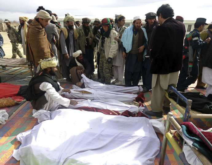 Afghan men gather around the bodies of victims of Sunday's suicide attack at a volleyball match in Yahya Khail district, Paktika province, November 24, 2014. (Reuters/Stringer)