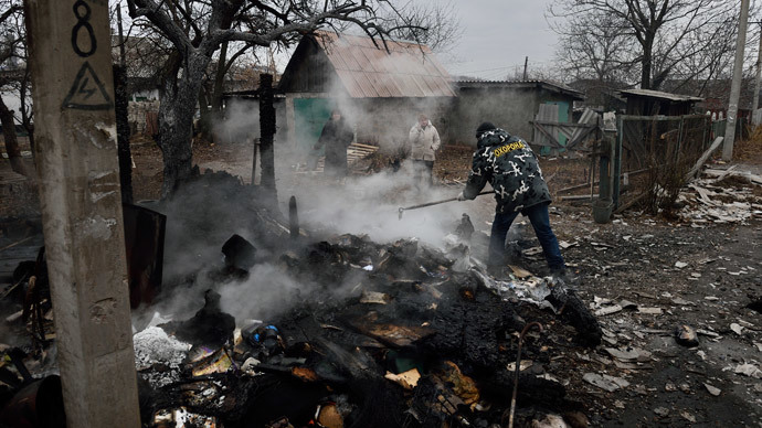 People stand by the remains of a shed after shelling, allegedly bythe Ukrainian army in the eastern Ukraine city of Donetsk on November 27, 2014. (AFP Photo / Eric Feferberg)