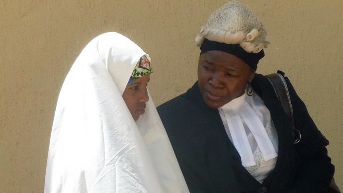 14-year old Wasila Tasiu speaks with an unidentified defence counsel outside the courtroom during a 30-minute break during her first day of trial at Kano state High Court in the village of Gezawa outside Kano on October 30, 2014. (AFP Photo/Aminu Abubakar)