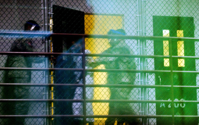 This image reviewed by the US military shot through a one way mirror shows guards moving a detainee from his cell in Cell Block A of the "Camp Six" detention facility of the Joint Detention Group at the US Naval Station in Guantanamo Bay (AFP Photo)