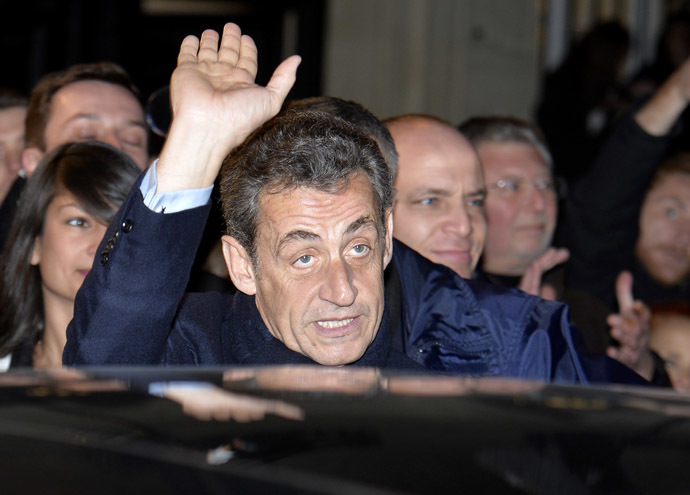 Former French President Nicolas Sarkozy, elected at the helm of the French right-wing main opposition party UMP, cheers his fans as he leaves on November 29, 2014 the UMP's headquarters in Paris. (AFP Photo/Miguel Medina)