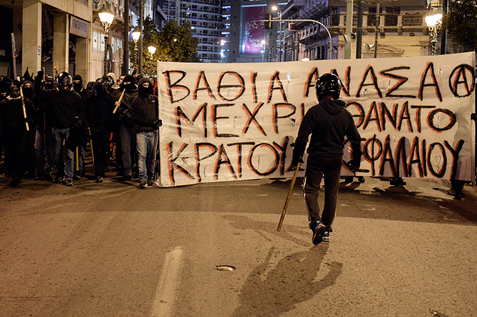 Anarchists carry a banner reading "Deep breath until the death of the state and the capital" in Athens on December 2, 2014 during a massive march in solidarity with a 22-years old anarchist hunger striker, Nikos Romanos (AFP Photo / Louisa Gouliamaki)