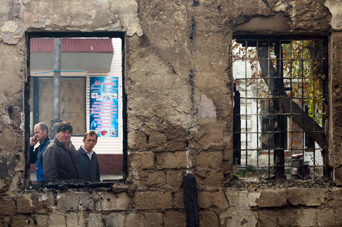 Local resident look at a destroyed building after recent shelling in the town of Popasna of Lugansk region on October 1, 2014. (AFP Photo/Anatolii Boiko)