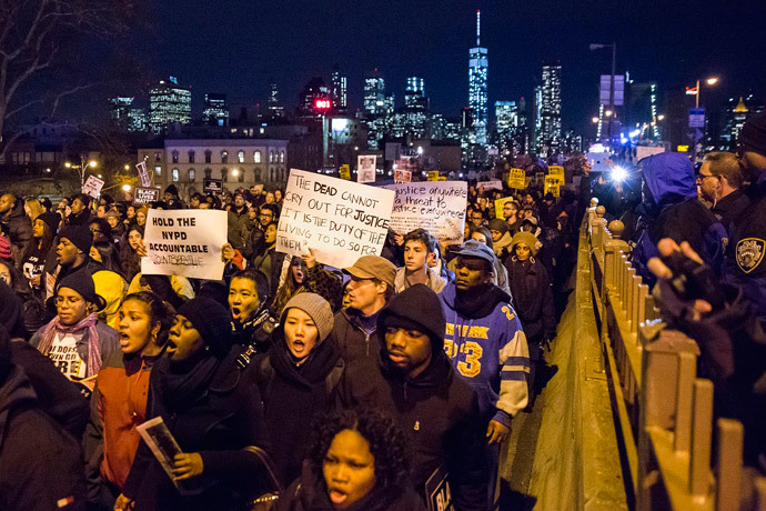 The Lower Manhattan skyline, including One World Trade Center, is seen in the background as protesters, demanding justice for Eric Garner, enter Brooklyn off the Brooklyn Bridge in New York December 4, 2014. (Reuters / Elizabeth Shafiroff)