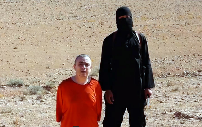 An image grab taken from a video released by the Islamic State (IS) via its "Al-Furqan Â» media arm on October 3, 2014 purportedly shows a masked militant (R) before the execution of British hostage Alan Henning dressed in orange and on his knees in a desert landscape. (AFP Photo / HO)