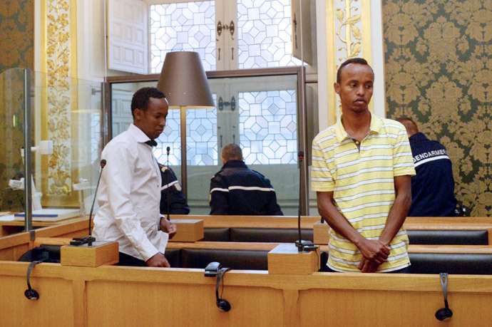 Two of the three Somali pirates arrested by French soldiers in 2009 Mahmoud Abdi Mohammed (L) and Abdelkader Osmane Ali wait in the accused box, on October 14, 2013 at Rennes' courthouse, prior to the opening hearing of their trial for hijacking a yacht in 2009. (AFP Photo / Damien Meyer)