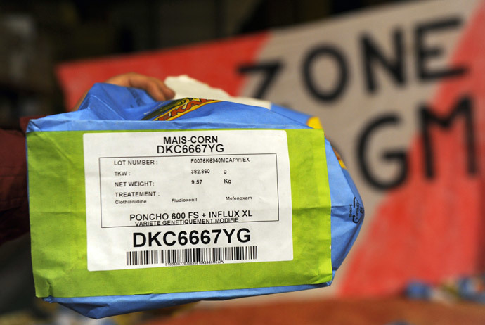 An anti-GMO activist holds a bag containing "MON 810", a variety of genetically modified maize (corn) developed by Monsanto (AFP Photo / Eric Cabanis)