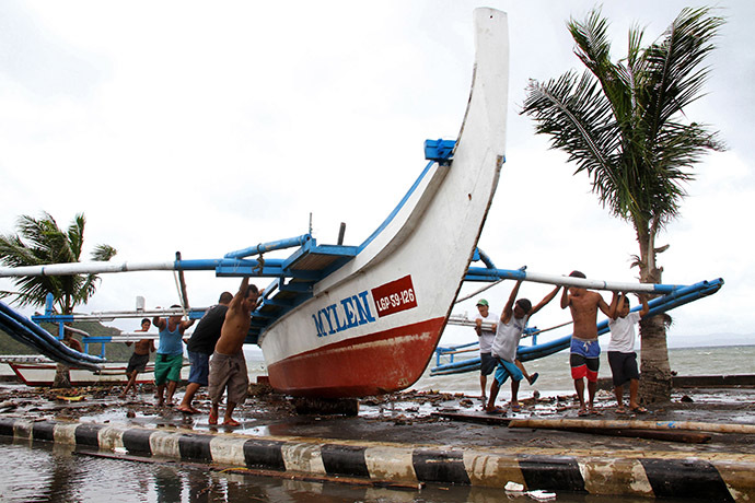 Fishermen carry thier outrigger to higher ground in Legazpi City, south of Manila on December 5, 2014, ahead of the landfall of Typhoon Hagupit. (AFP Photo/Charism Sayat)