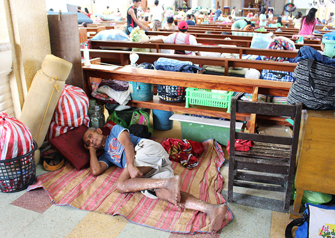 A man rests inside a church after residents evacuated their homes due to super-typhoon Hagupit in Tacloban city, central Philippines December 5, 2014.(Reuters/Rowel Montes)
