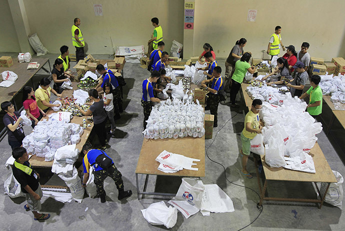 Soldiers and volunteers prepare relief goods, to be delivered before Typhoon Hagupit makes landfall, inside a Department of Social Welfare and Development (DSWD) warehouse in Manila, December 6, 2014. (Reuters/Romeo Ranoco)