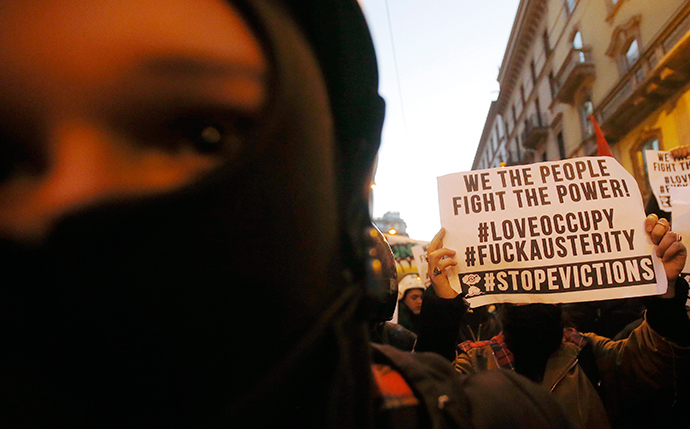 A demonstrator holds a placard during a protest in front of La Scala opera house on the first day of opera season in downtown Milan December 7, 2014 (Reuters / Alessandro Garofalo)