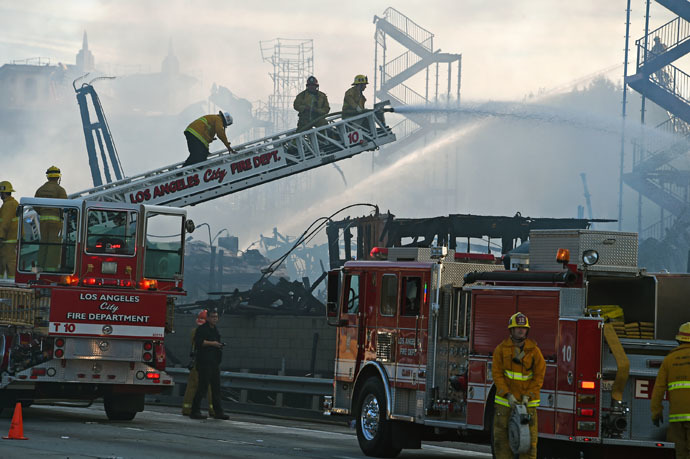 Firefighters douse the remains of a fire that destroyed an apartment complex that was under construction, in downtown Los Angeles, California, December 8, 2014. (AFP Photo/Robyn Beck)