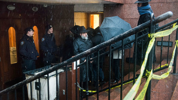 Police keep guard as men walk past police tape outside of the world headquarters of the Chabad-Lubavitch movement, the scene of a stabbing at the Brooklyn synagogue in New York City December 9, 2014.(Reuters / Stephanie Keith)