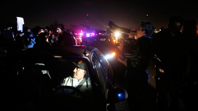 A stranded motorist sits in his car as protesters block traffic on Highway 80 during a march against the New York City grand jury decision to not indict in the death of Eric Garner in Berkeley, California December 8, 2014. (Reuters / Stephen Lam)